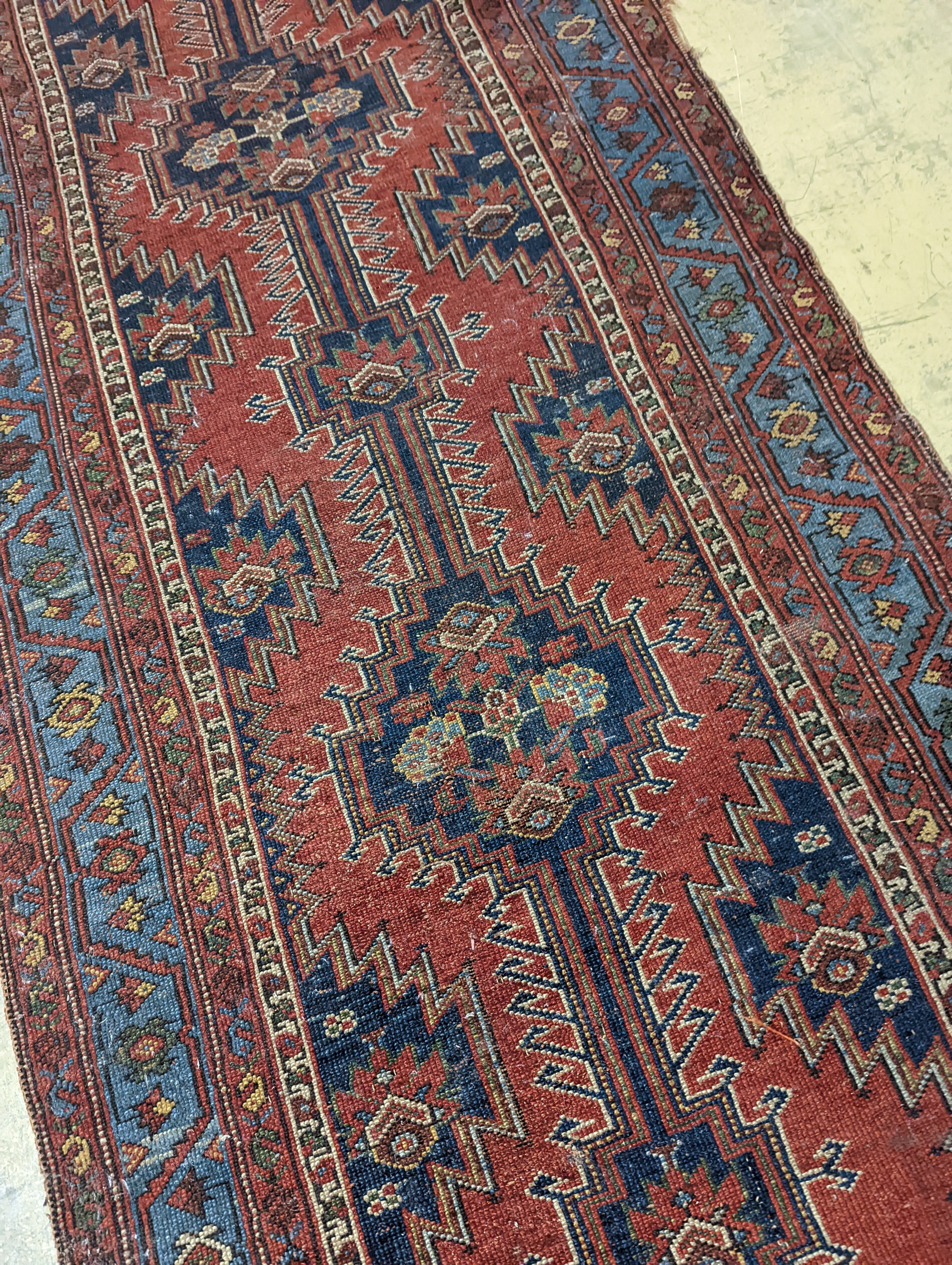 An antique Caucasian red ground runner, 380 x 100cm